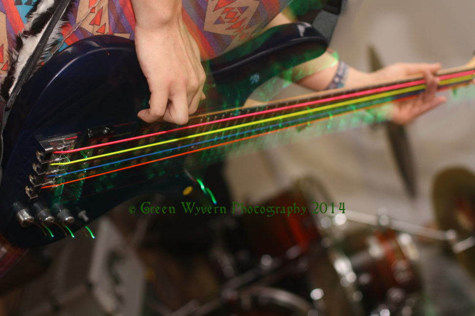 Bass guitar with multicoloured strings blurred by movement